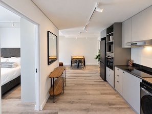 Eine moderne Küche mit Essbereich, einer Bank und einem Bett mit Kopfteil.
