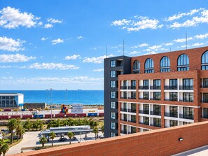 Un edificio moderno con varios pisos, ventanas amplias y vista al mar.