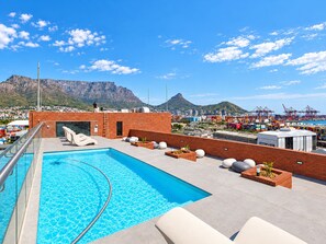 A rooftop pool with a clear view of a port and mountains in the background. - Maritime Place (Cape Town)