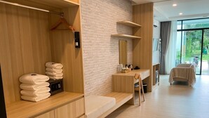Une chambre d’hôtel moderne avec un banc en bois, un miroir et une vue sur l’extérieur.