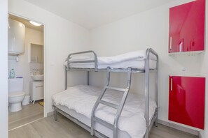A bunk bed room with a bathroom and a red cabinet. - Studio "Location Prapoutel" with Mountain View and Balcony (Les Adrets)