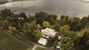 An aerial view of a large estate with a prominent building surrounded by dense trees and a body of water. - Apartment 'Am Lindenhof' with Balcony and Wi-Fi (Lindau (Bodensee))