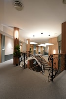 Ein modernes Interieur mit Treppe, Holzvertäfelung und einer Zimmerpflanze.