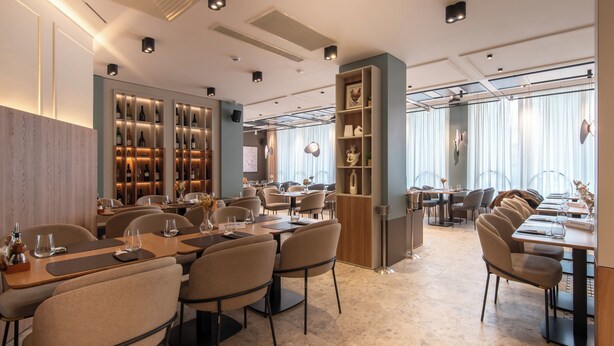 A modern restaurant with multiple dining areas, ambient lighting, and a variety of seating options. - Hotel Botika (Kraljevo)
