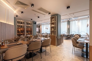Ein modernes Restaurant mit verschiedenen Essbereichen, stimmungsvoller Beleuchtung und vielfältigen Sitzgelegenheiten.