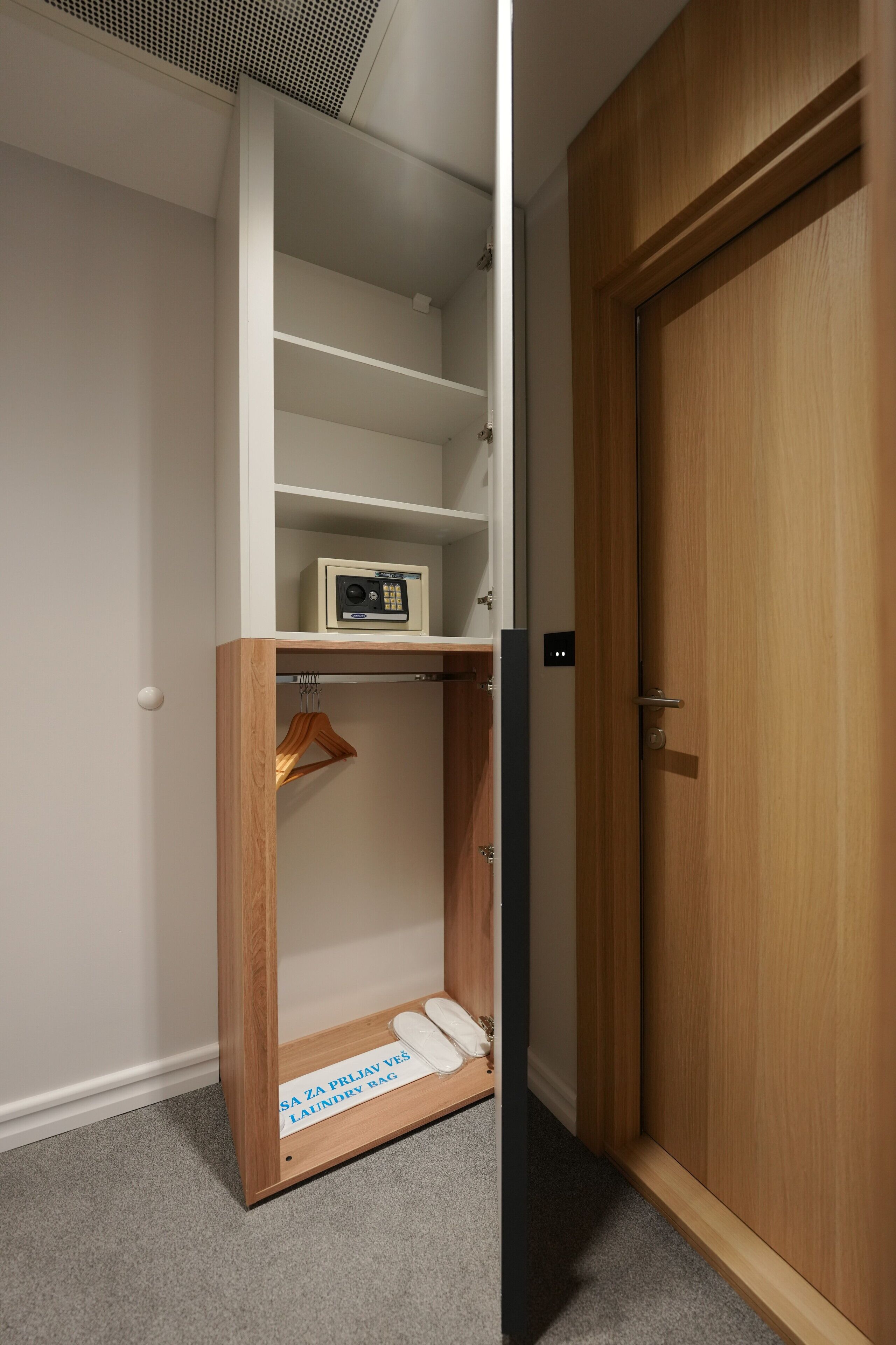 A closet with a hanging rack, a radio, and a sign indicating a laundry bag.