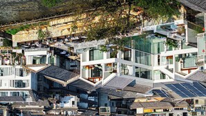 Un bâtiment moderne à plusieurs niveaux, doté de grandes fenêtres et présentant un mélange de styles architecturaux traditionnels et contemporains.