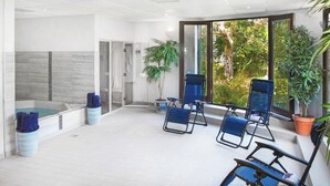 A modern indoor pool area with a jacuzzi, lounge chairs, and potted plants. - Ivy Cottage, idyllic coastal retreat with sea views (Bideford)