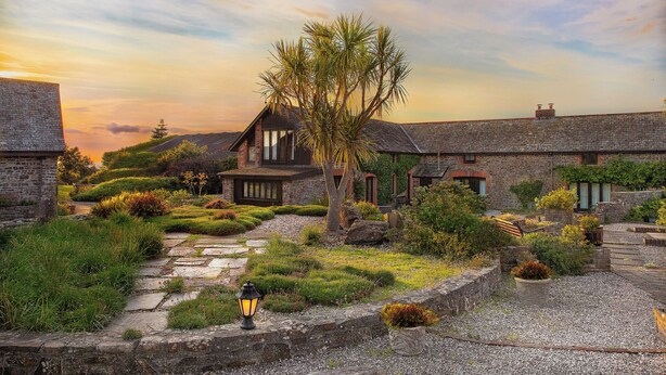 A stone building with a garden pathway, a tree, and a lantern. - Ivy Cottage, idyllic coastal retreat with sea views (Bideford)