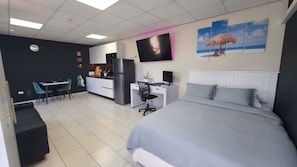 A modern bedroom with a bed, a desk, a chair, and a TV. - Serene apartment with AC in vibrant Santa Cruz (Santa Cruz)