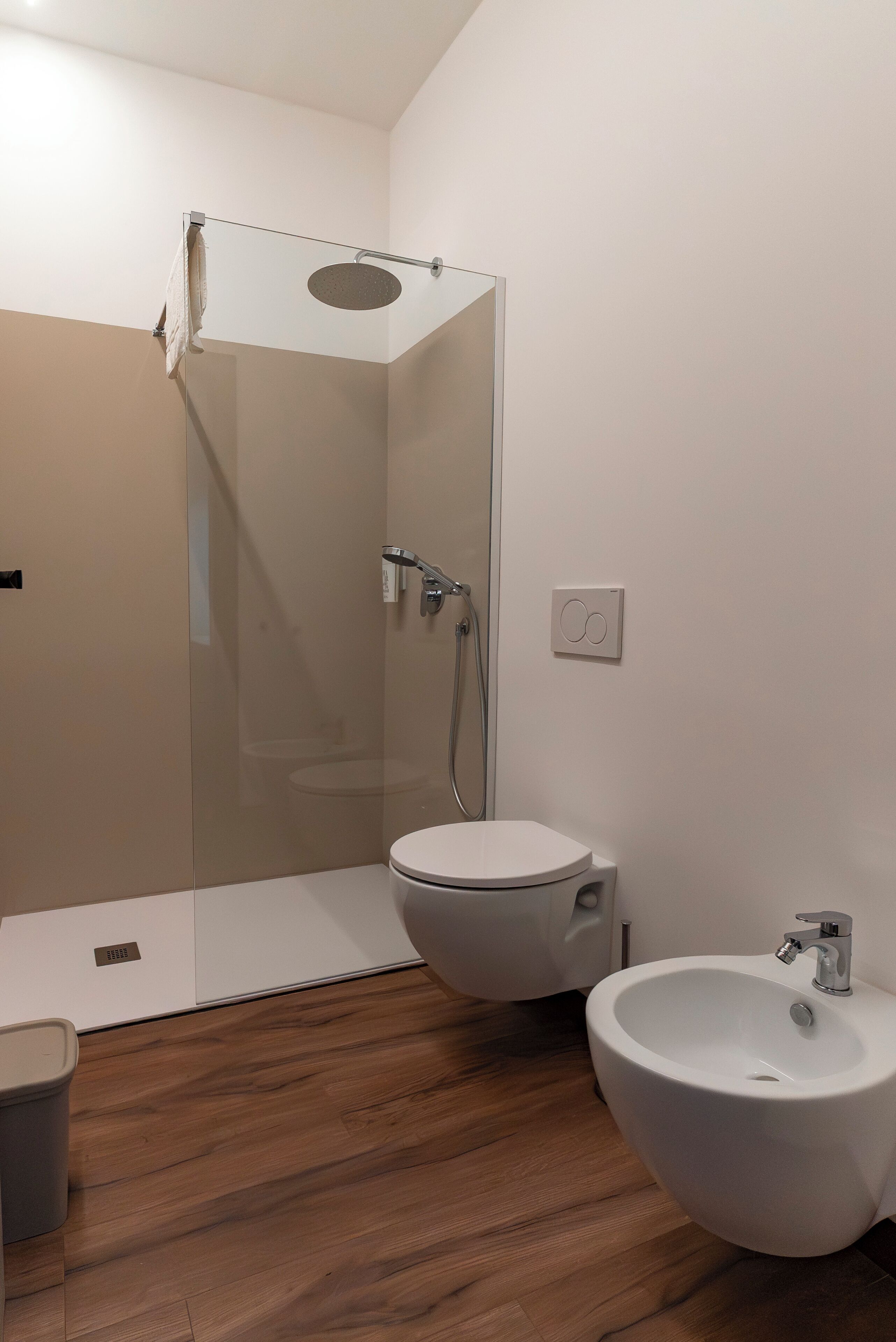 Un baño moderno con ducha de vidrio, inodoro y bidé.