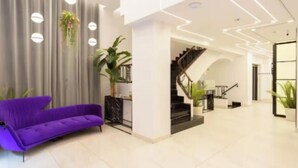 Ein modernes Interieur mit einem violetten Sofa, einer Treppe und einem minimalistischen Design.
