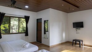 A room with two beds, a TV, a ceiling fan, and a window with curtains. - Awas Beach Stays By Glitz (Awas)
