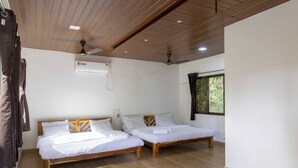 A room with two wooden beds, a ceiling fan, an air conditioning unit, and a window with curtains. - Awas Beach Stays By Glitz (Awas)