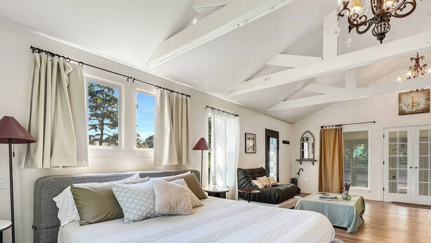 Een ruime slaapkamer met een groot bed, een zithoek en uitzicht op de omgeving.