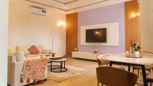 A modern living room with a sofa, coffee table, and dining table. - Cozy 1-bedroom apartment in serene Calavi with AC (calavi)