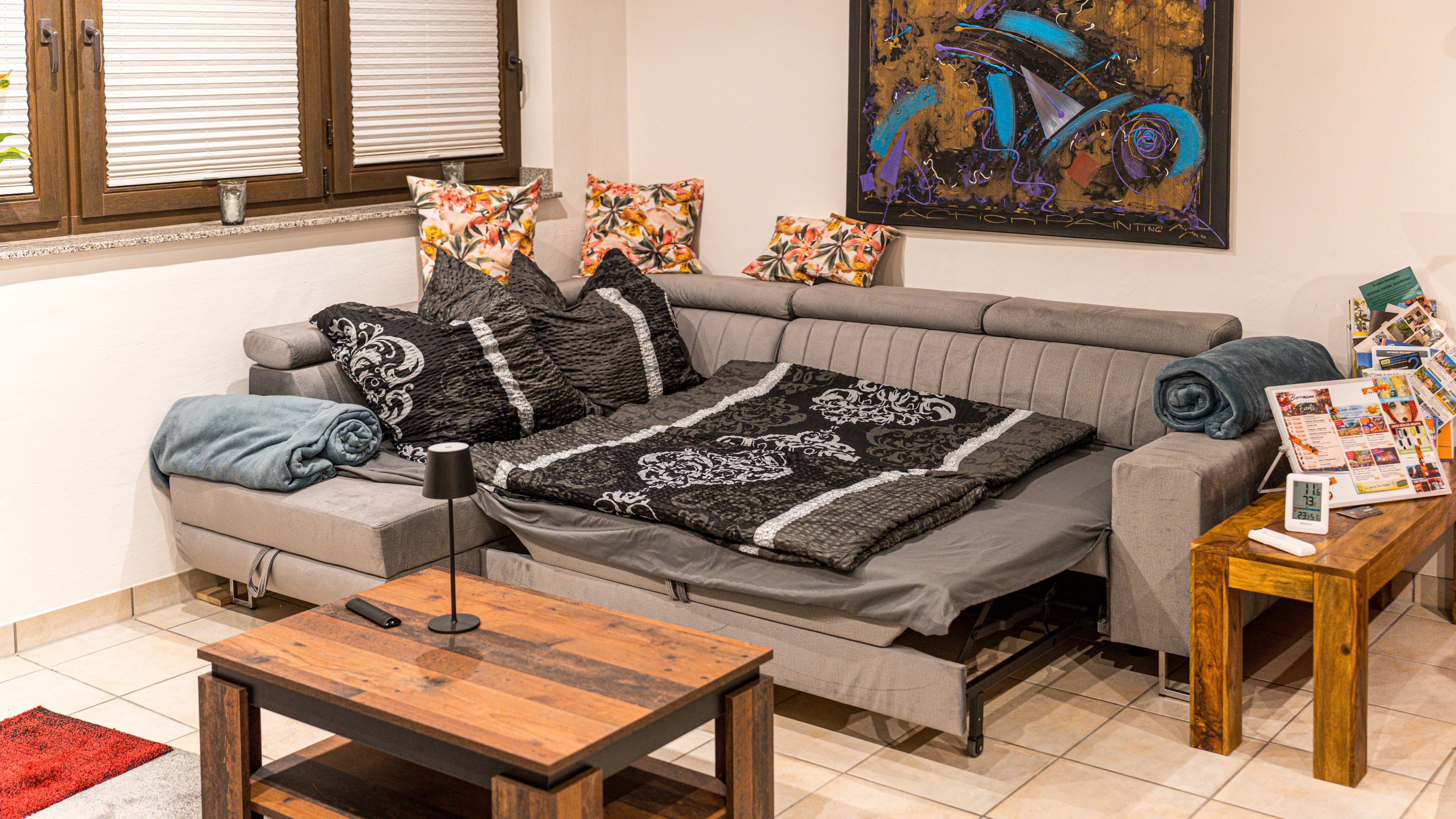 A living room with a sofa, a coffee table, and a painting on the wall.