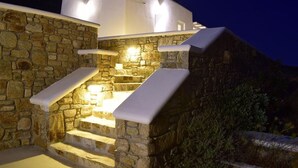 Eine Steintreppe führt zu einem weißen Gebäude, dessen Stufen beleuchtet sind.
