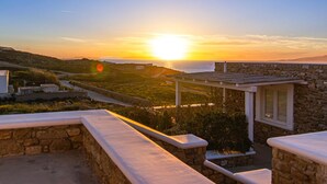 Ein Steinhaus mit Blick auf den Sonnenuntergang über dem Meer.