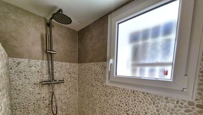 Regadera, secadora de cabello, toallas, papel de baño 