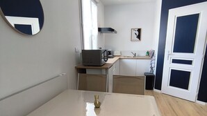 Una cocina compacta con mesa y sillas, microondas y fregadero.