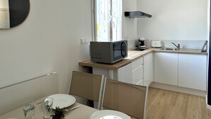 Cocina compacta con microondas, cafetera y lavamanos.