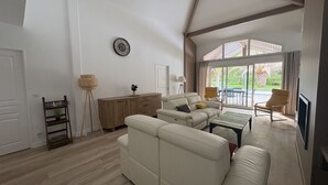 Ett rymligt vardagsrum med en soffa, ett soffbord och utsikt över omgivningarna.