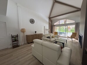 A spacious living area with a sofa, coffee table, and a view of the outdoors.