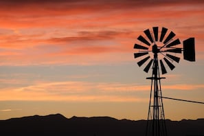 A silhouette of a windmill against a sunset sky. - Tarantula Ranch Vineyard - Death Valley (Amargosa Valley)
