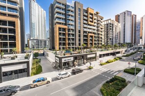 Ein modernes Stadthotel mit mehreren Hochhäusern, einer Dachterrasse und Blick auf die Straße mit Autos.