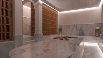 A modern bathroom with a marble vanity, wooden slatted doors, and a marble floor.