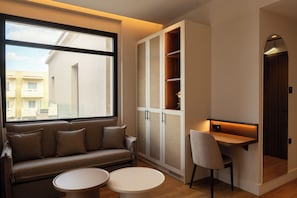 Quarto moderno com sofá, mesinha, cadeira e estantes embutidas.