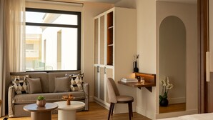 Una habitación de hotel moderna con una cama grande, un sofá, un escritorio y vistas al exterior.