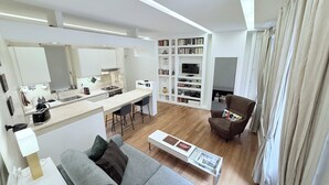 En moderne opholdsstue med køkken, spiseplads og siddeområde.