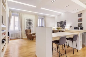 A modern kitchen with a central island, bar stools, and a dining area. - Campo dei Fiori. modern and quiet apartment with patio and A/C. (Roma)