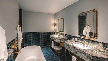 Une salle de bain moderne avec une baignoire, deux lavabos et un grand miroir.