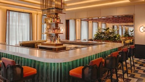 A bar area with a central bar, seating, and a decorative ceiling.