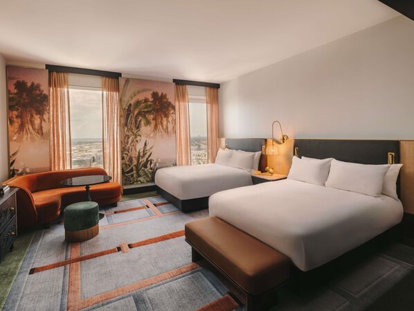 A hotel room with two beds, a sofa, a small table, and a view of the city. - Fairmont New Orleans (Opening November 2026) (New Orleans)