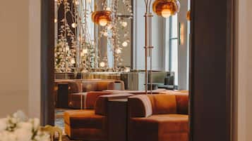 A modern interior with seating areas, a decorative light fixture, and a view of the outdoors.