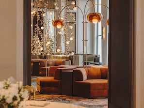 Un interior moderno con zonas de estar, una lámpara decorativa y vistas al exterior.