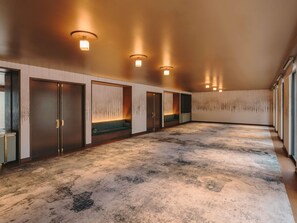 A spacious room with a patterned carpet, recessed lighting, and a seating area with a bench. - Fairmont New Orleans (Opening November 2026) (New Orleans)