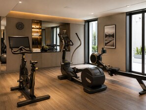 A modern home gym with exercise equipment, a TV, and a large window. - ibis Styles Saint Germain en Laye (Opening October 2026) (Saint-Germain-en-Laye)