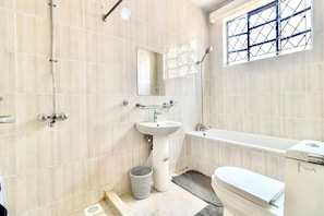 A bathroom with a sink, mirror, shower, and toilet. - Amboseli home away from home  3-bedroom apartment in Nairobi (Nairobi)