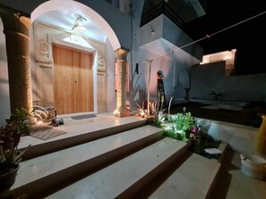 A well-lit entrance with a wooden door, stone columns, and steps leading to a covered area. - Villa Paradise in Hammamet sleeps 12 with swimming pool (heated at extra cost) (Hammamet)