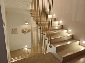 A staircase with a modern design, featuring a wooden finish and a rope barrier. - Villa Paradise in Hammamet sleeps 12 with swimming pool (heated at extra cost) (Hammamet)