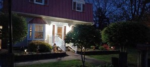 A two-story house with a front porch, a staircase, and a well-maintained garden.