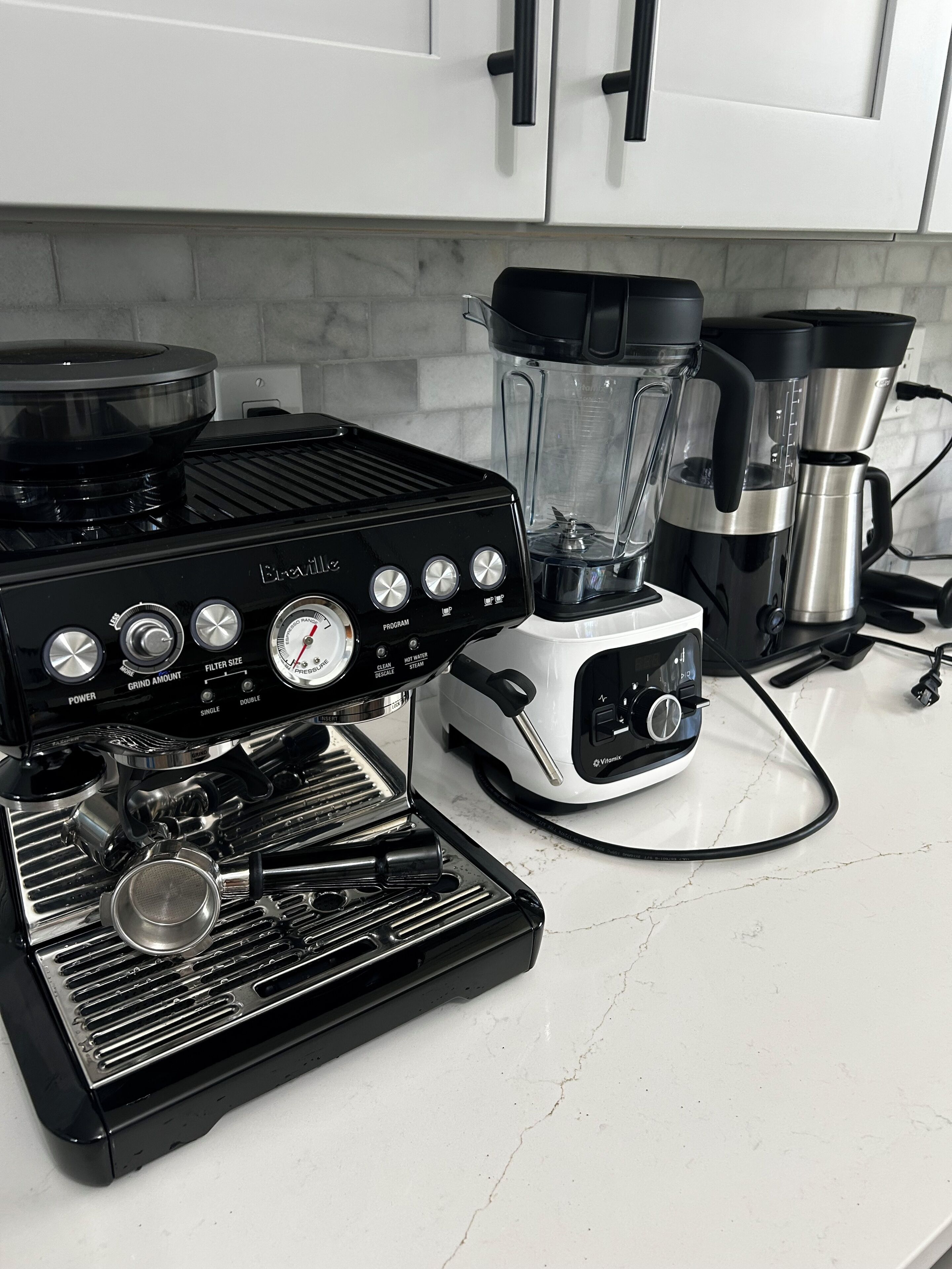 Une cuisine équipée d’une machine à café, d’un mixeur et d’une cuisinière.