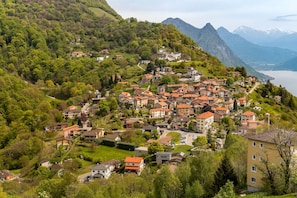 A hillside village with traditional buildings, a lake view, and mountainous backdrop. - Charm Apartments (Lugano)