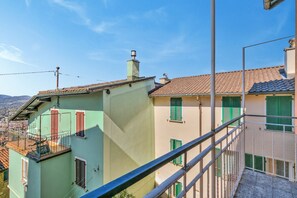A multi-story building with balconies, green shutters, and a clear sky. - Charm Apartments (Lugano)