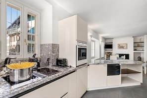Una cocina moderna con horno empotrado, estufa y pileta.